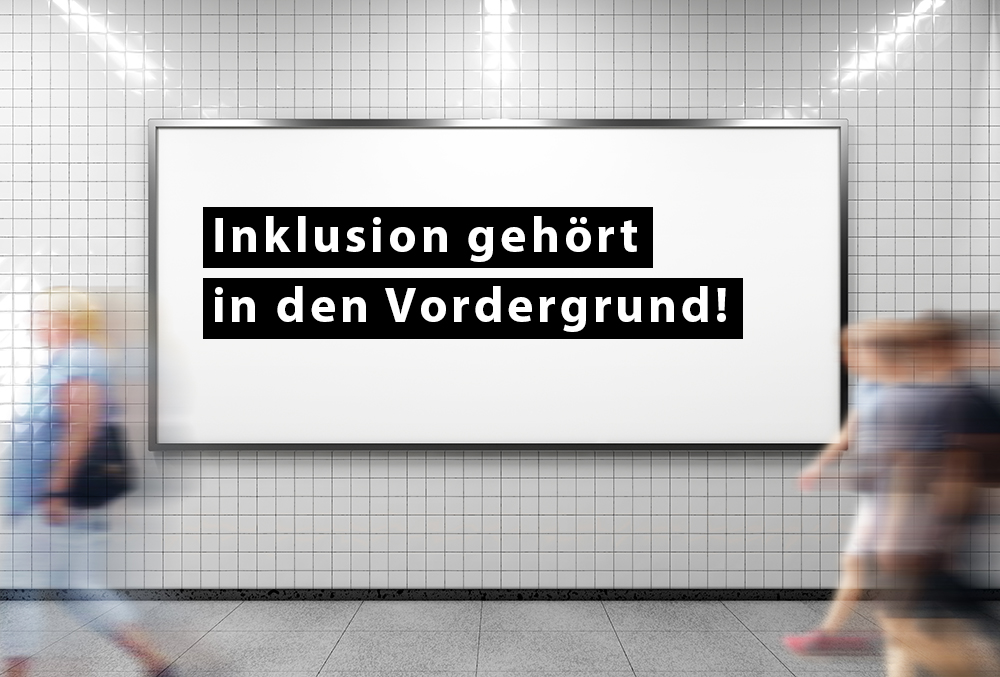 Werbetafel in einer U-Bahn-Station mit der Aufschrift: Inklusion gehört in den Vordergrund!
