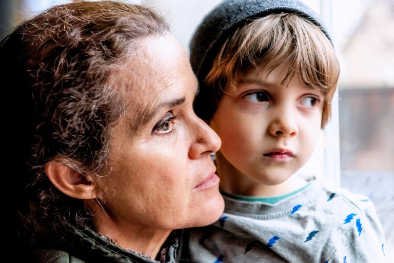 Frau mit ihrem Sohn, sehr traurig Blick durch das Fenster traurig über den Verlust ihres Partners