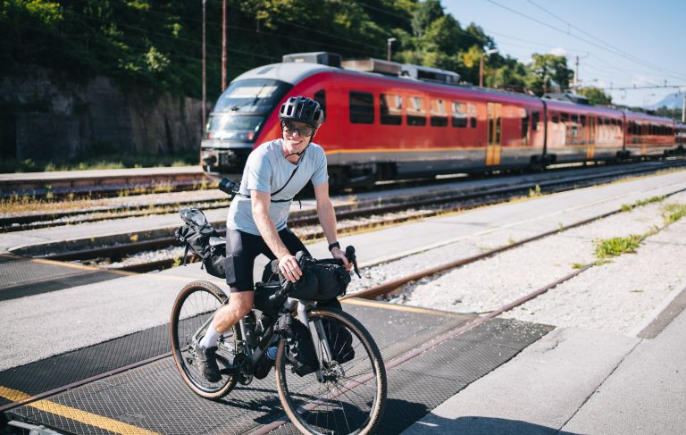 Mann fährt mit fahrrad über Bahngleise