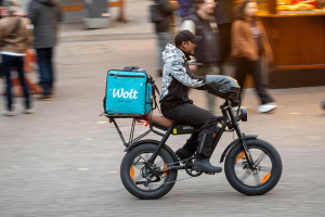 City centre, shopping street, pedestrian zone Kettwiger Straße in Essen, bicycle courier from the delivery service Wolt on an e-fatbike, before the op