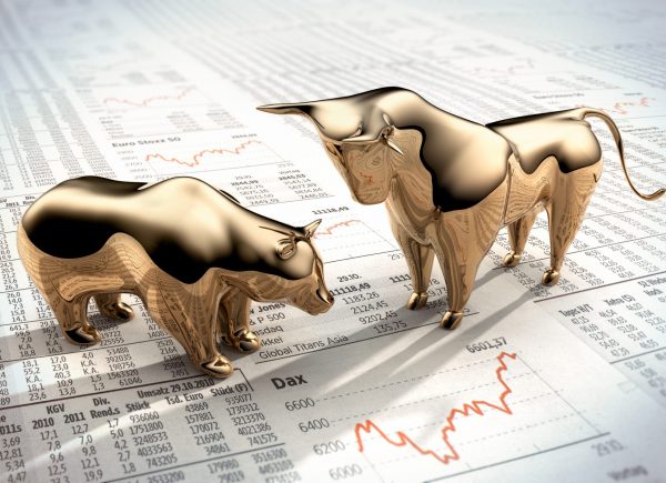 Goldener Bulle und Bär auf Börsenkursen